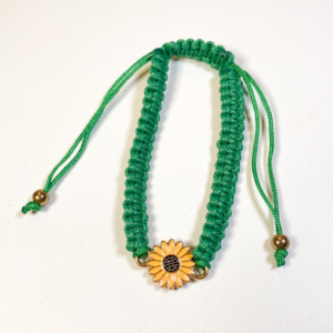 Green adjustable sunflower cord bracelet with gold-tone charm on white background